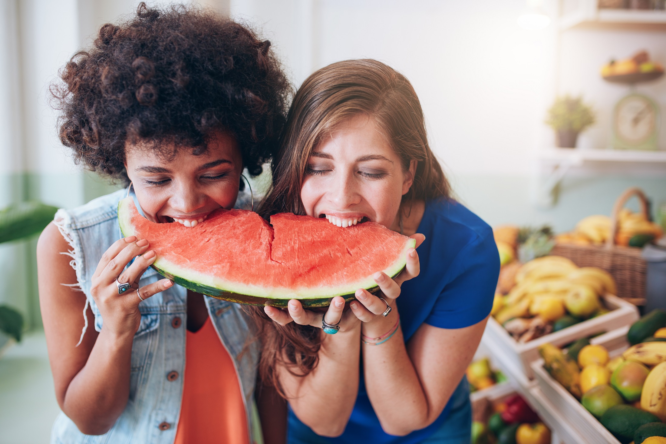 two young woman eating watermelon and having fun PTGRUAU